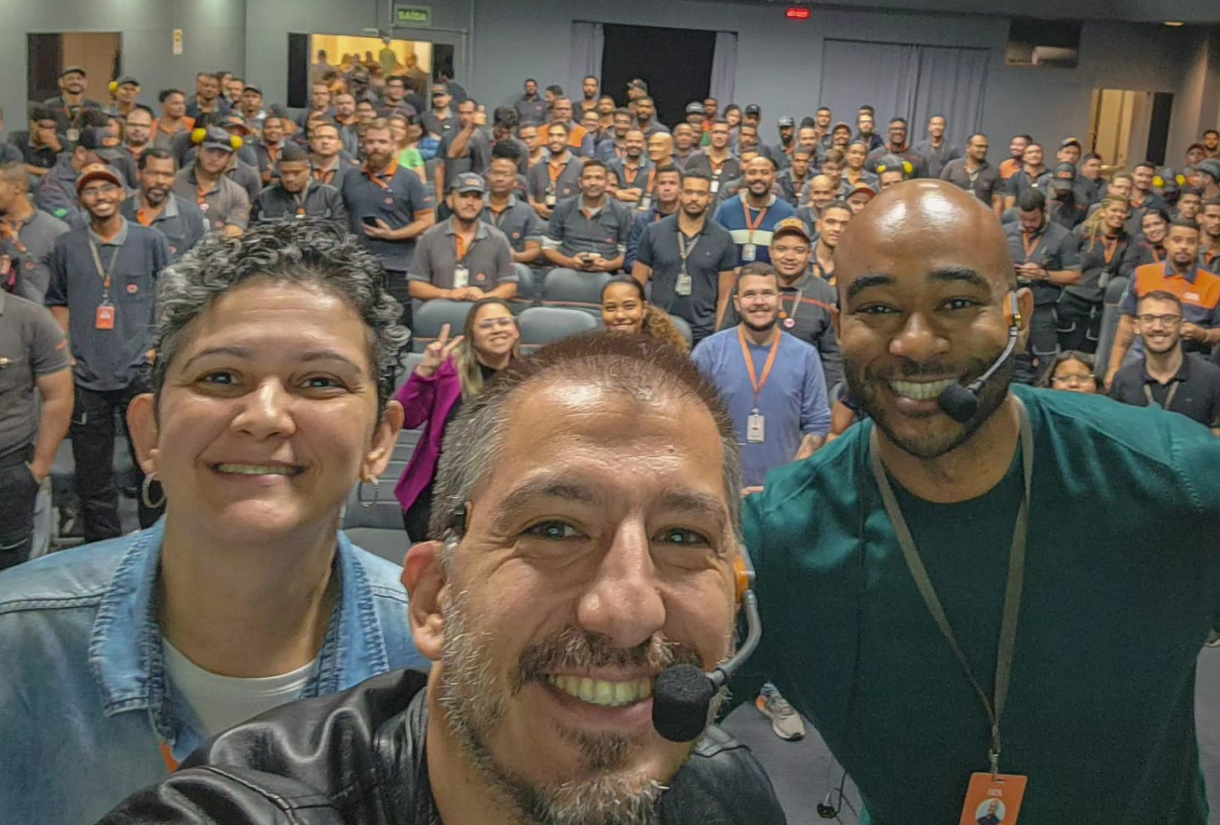 Afonso Krücken Martin em palestra, selfie com dois colegas e centenas de participantes ao fundo